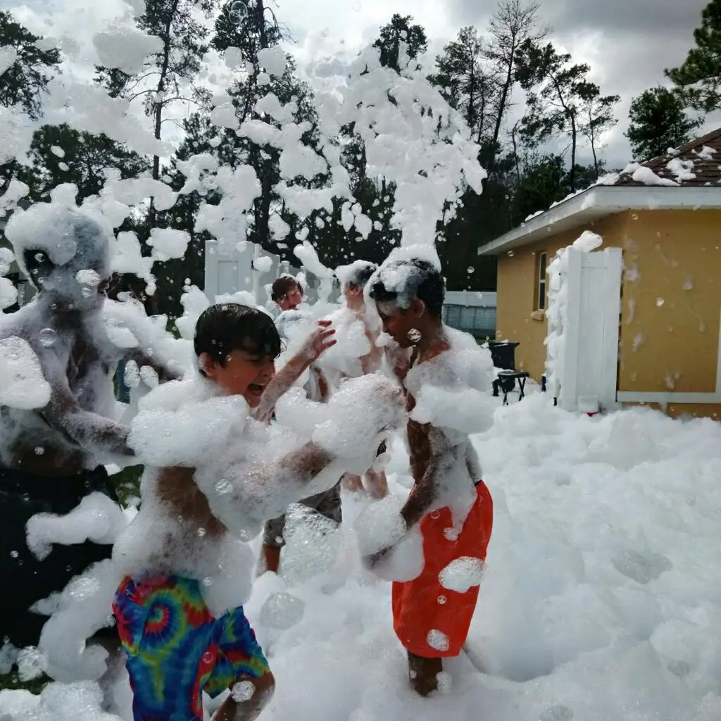 A group of people playing with foam in the yard.