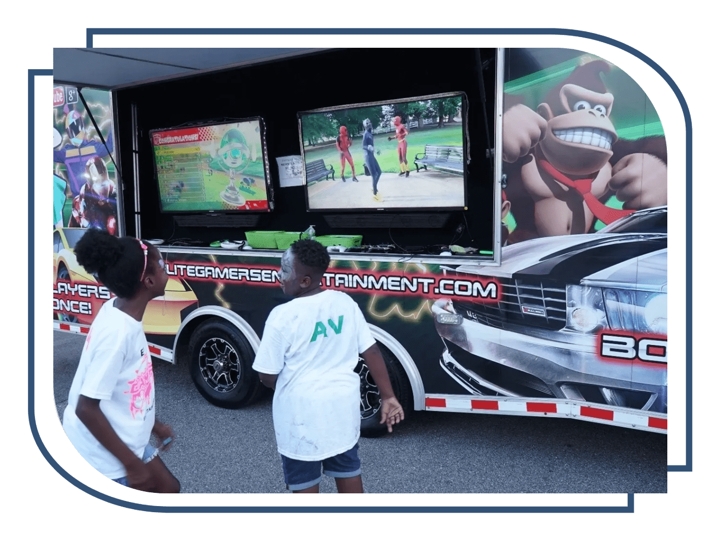 Two young boys standing in front of a television truck.